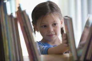 Caucasian girl taking book from shelf